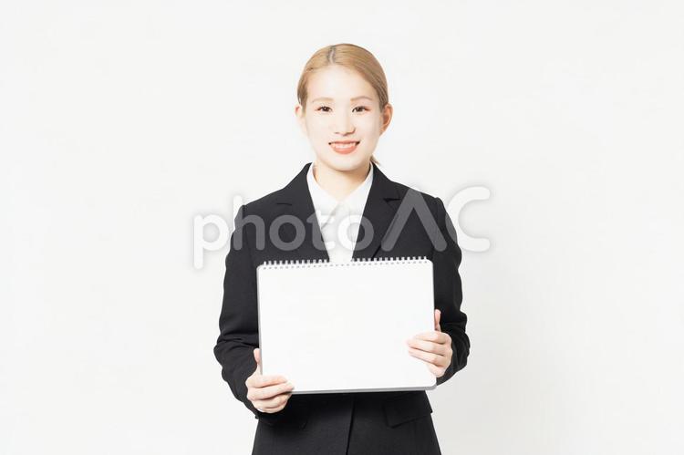 小さいスケッチブックを見せる若い女性 スケッチブック,見せる,若いの写真素材