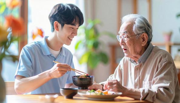 食事介助をする男性介護士と高齢男性 食事介助をする男性介護士と高齢男性の写真