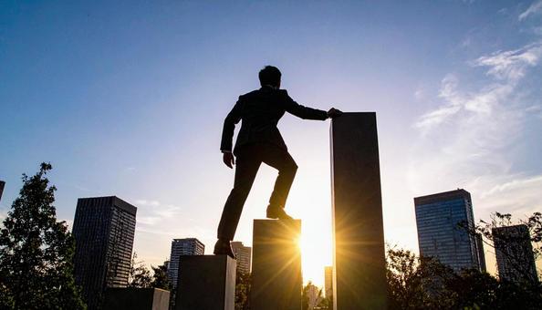 都市背景に階段を上がっていくビジネスマン 都市背景に階段を上がっていくビジネスマンの写真