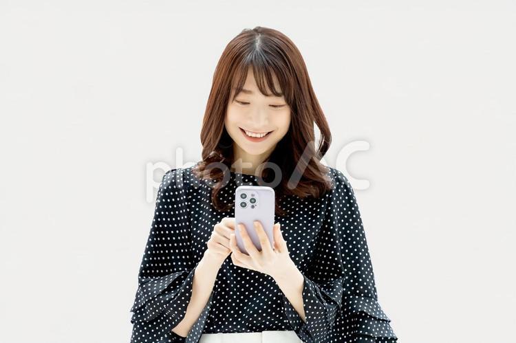 スマホを使う笑顔の女性・ビジネスウーマン 女性,スマホ,スマートフォンの写真素材