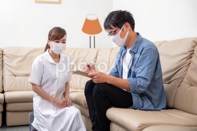 問診票に記入する看護師と患者 病院,看護師,問診票の写真素材