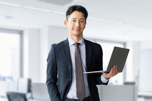 ノートパソコンを持つ男性ビジネスマン 男性,パソコン,ノートパソコンの写真素材