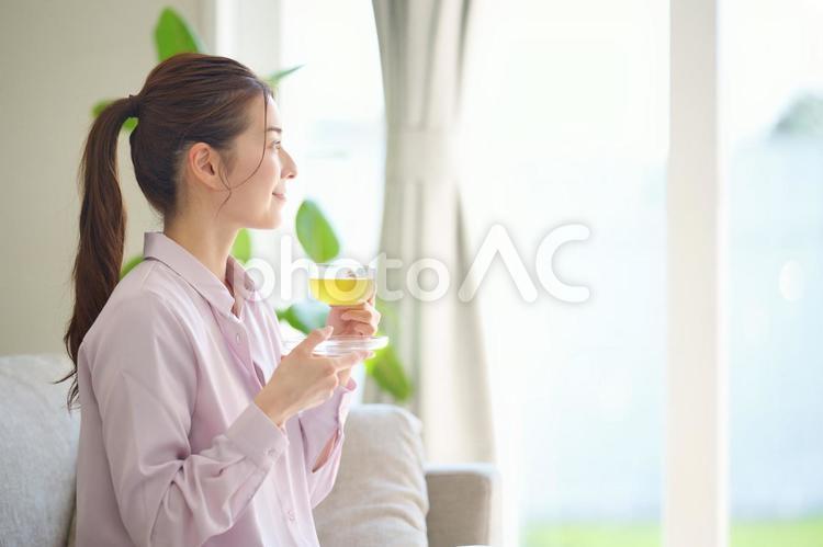 ソファーに座ってお茶を飲む女性 女性,日本人,大人の写真素材