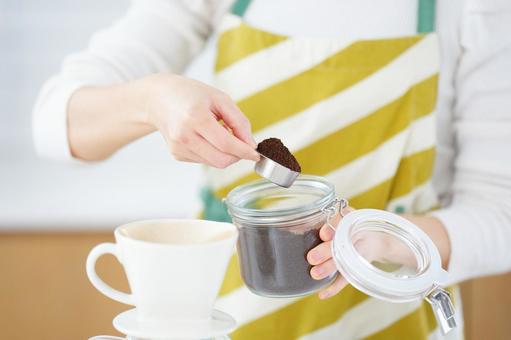 コーヒーの粉の容器を持つ手 コーヒーの粉の容器を持つ手の写真