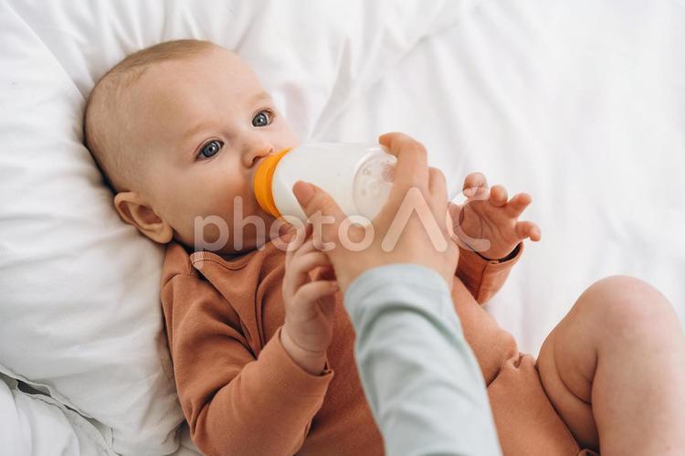 哺乳瓶を持ち赤ちゃんに飲ませている手 赤ちゃん,飲む,ミルクの写真素材