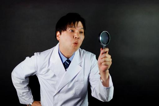 虫眼鏡で調査する男性 虫眼鏡で調査する男性の写真