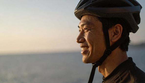 自転車用ヘルメットをかぶる男性 自転車用ヘルメットをかぶる男性の写真