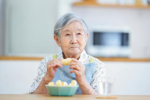 両手でカットリンゴを持つ高齢女性 女性,リンゴ,持つの写真素材