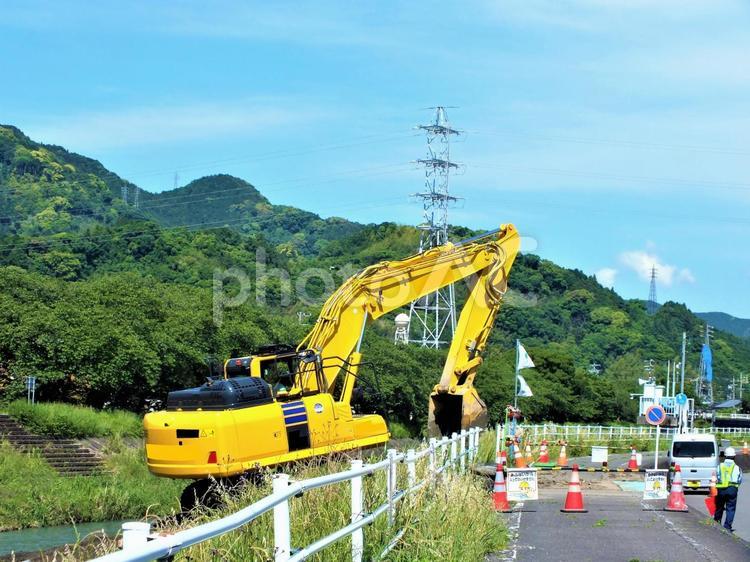 土手に上がって作業を続けるショベルカー ショベルカー,すくいあげる,パワーショベルの写真素材