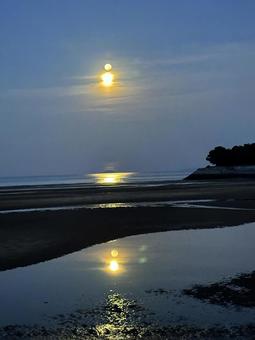 父母が浜の海に映る月の入り_明け方の空 父母が浜,海,月の入りの写真素材