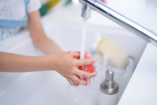 蛇口の水でトマトを洗う子どもの手元 トマト,水道,蛇口の写真素材