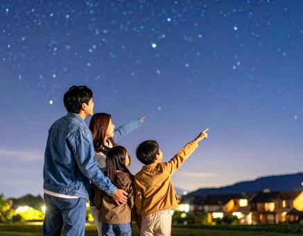 星空の下で夜空を見上げる家族 星空の下で夜空を見上げる家族の写真