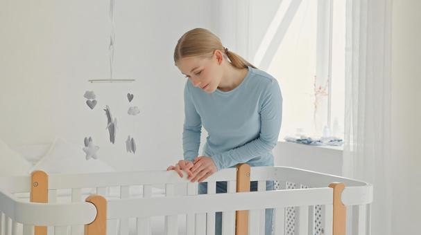 ベビーベッドの上から微笑み赤ちゃんを見つめる女性 ベビーベッドの上から微笑み赤ちゃんを見つめる女性 女性,見る,微笑むの写真素材
