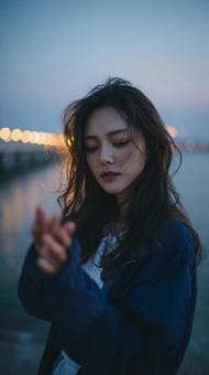 切ない表情の女性と夜の光 切ない表情の女性と夜の光の写真