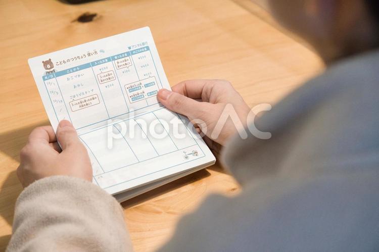 通帳をみて残高確認する主婦 通帳,貯金,お金の写真素材