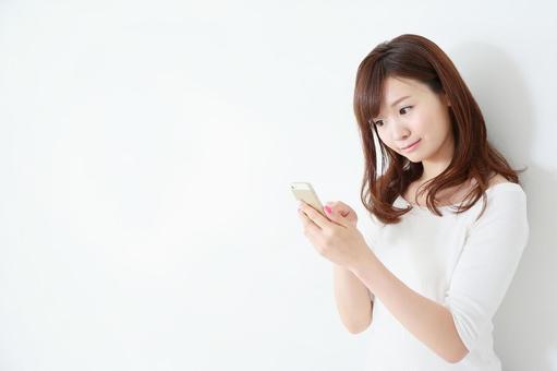 スマートフォンを使う女性 スマートフォンを使う女性 スマートフォン,カジュアル,検索の写真素材