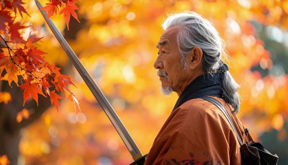 紅葉を背景に刀を持つ高齢男性 紅葉を背景に刀を持つ高齢男性の写真