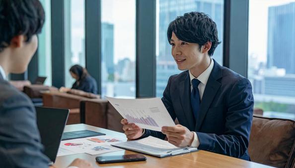 オフィスで商談する日本人ビジネスマン オフィスで商談する日本人ビジネスマンの写真