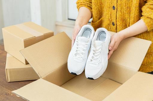 スニーカーを梱包する手元 スニーカー,運動靴,靴の写真素材