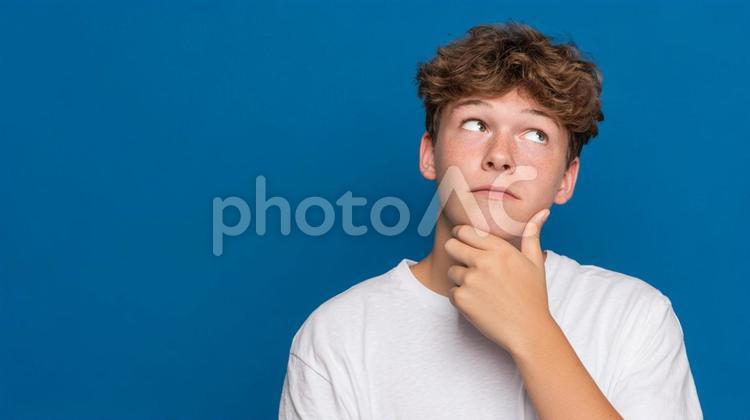 上を見上げ、何かに思いを馳せる若者 ティーンエイジャー,若者,男性の写真素材