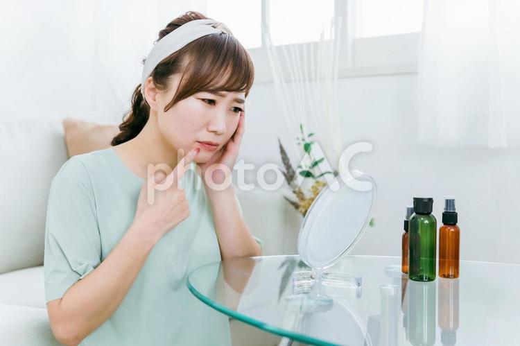 鏡を見て肌に悩む女性（ほうれい線・シワ） 唇,ほうれい線,しわの写真素材