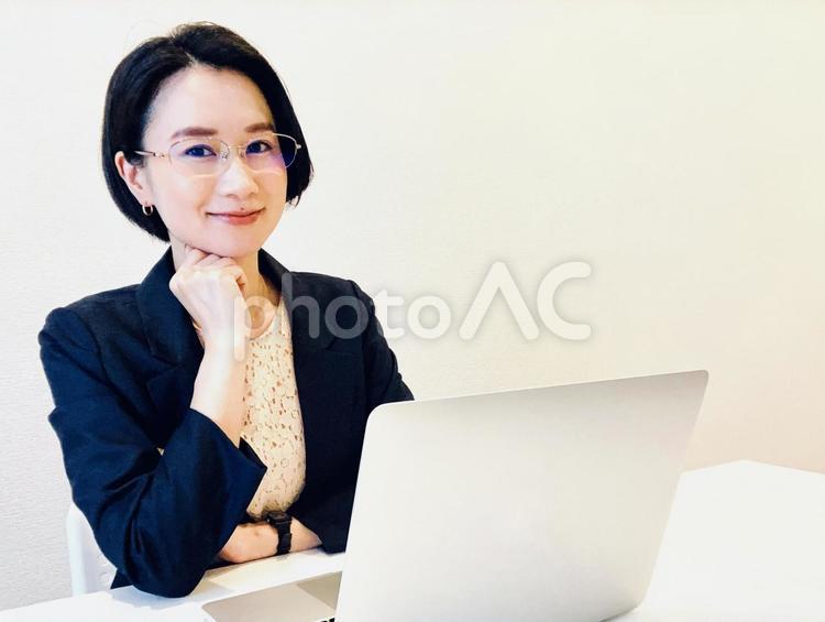 パソコンの前で話を聞くビジネスウーマン 女性,パソコン,ポイントの写真素材