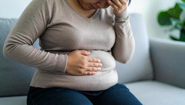肥満で疲れやすく、額に手をやる女性 肥満で疲れやすく、額に手をやる女性の写真