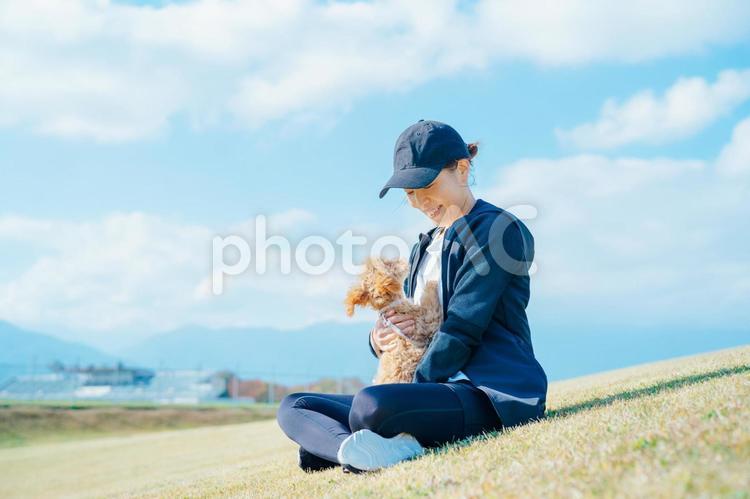 スポーツウェアで犬の散歩をする女性（抱く） 犬,ペット,女性の写真素材