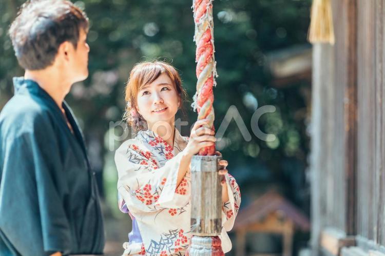 お参りして鈴を鳴らす浴衣姿の男女 神社,お参り,鈴の写真素材
