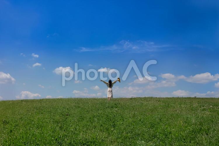 青空の下で両手を広げる女性 青空,空,雲の写真素材