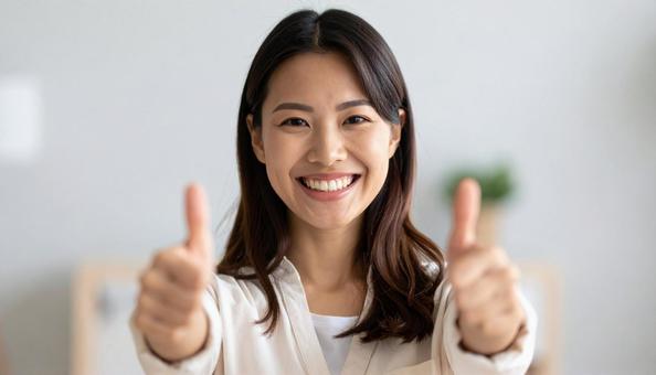 親指を立ててサムズアップしている女性の写真