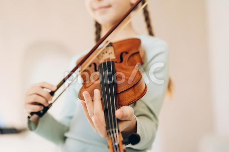 バイオリンを練習する女の子の下からのアングル 鼻から下,バイオリン,おさげの写真素材