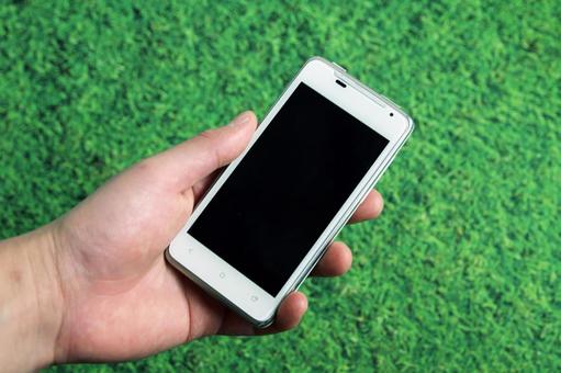 スマートフォンを持つ手 スマートフォンを持つ手 スマートフォン,手,屋外の写真素材