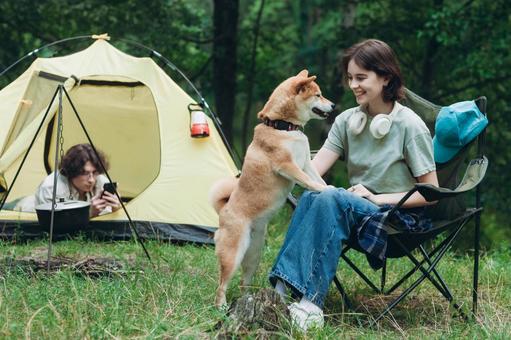 犬と並んでくつろぐ男性と女性の写真