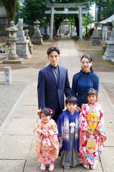 神社の鳥居の前で並ぶ晴れ着姿の家族 神社の鳥居の前で並ぶ晴れ着姿の家族 七五三,お参り,七五三参りの写真素材