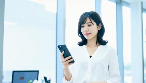 スマホを確認するビジネス女性 スマホを確認するビジネス女性の写真