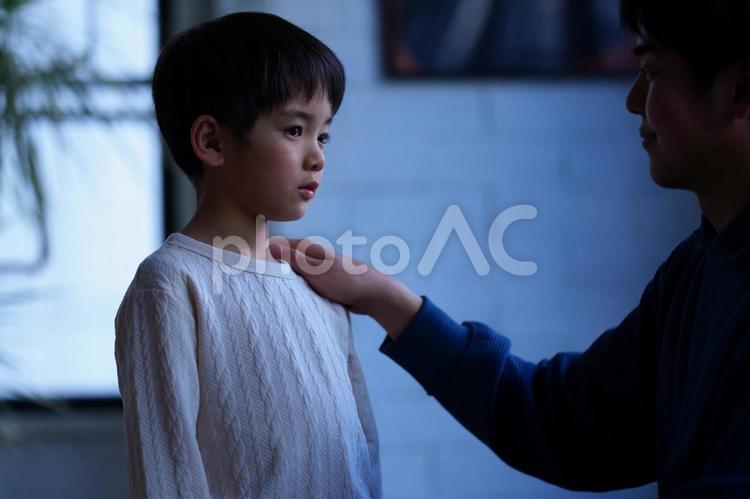 暗がりで励ます男性 親子,男の子,小学生の写真素材