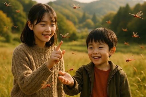 里山で赤とんぼと遊ぶ姉弟 里山で赤とんぼと遊ぶ姉弟の写真