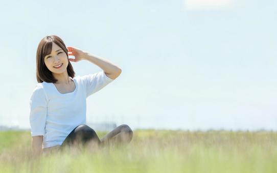 丘の上で微笑む女性 丘の上で微笑む女性 女性,丘,ストレッチの写真素材