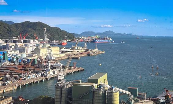 港と貨物船が並ぶ工業エリアと青い海の風景 港と貨物船が並ぶ工業エリアと青い海の風景 港,貨物船,工場の写真素材