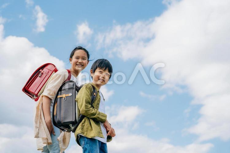 空と小学生（振り向く） 小学生,青空,子どもの写真素材