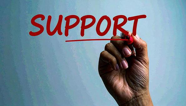 文字「Support」と赤ペンで書く手元 文字「Support」と赤ペンで書く手元の写真
