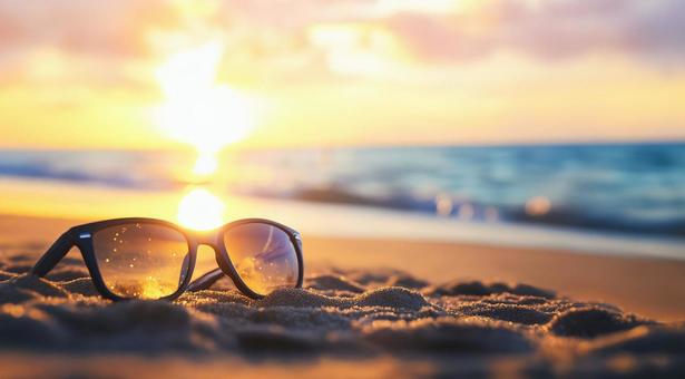 オレンジ色の太陽が照らす夏の砂浜の風景 オレンジ色の太陽が照らす夏の砂浜の風景の写真