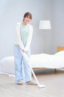 カメラ目線で掃除機をかける女性 女性,掃除機,掃除の写真素材