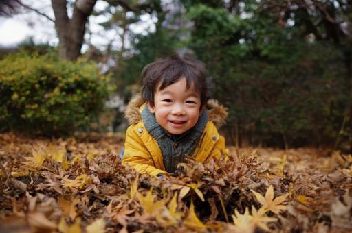落ち葉で遊ぶ子ども-1 落ち葉で遊ぶ子ども-1の写真