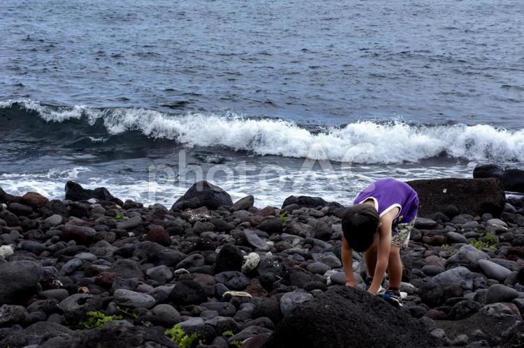 ＜素材＞夏の荒れた海を一人散策する男の子 子供,男性,人物の写真素材
