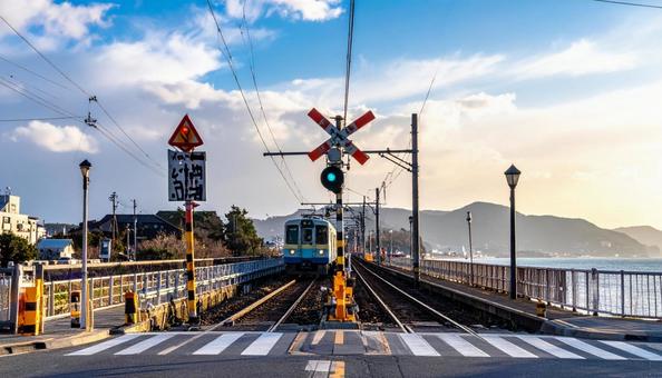 駅の踏切を走る電車 駅の踏切を走る電車の写真