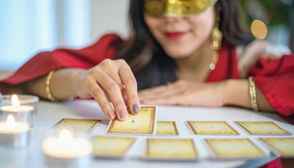 タロット占いをする仮面の占い師 タロット占いをする仮面の占い師の写真