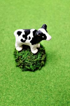 丘の上に立つ粘土で作った牛の縦写真 牛,手作り,クレイの写真素材