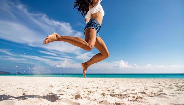 砂浜をジャンプする女性の足 砂浜をジャンプする女性の足の写真
